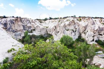 Travel to Turkey - slope of ravine with rock-cut ancient monastic settlement near Goreme town in Cappadocia in spring