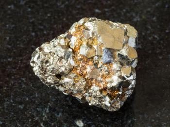 macro shooting of natural rock specimen - crystalline iron pyrite (fool's gold) stone on black granite background
