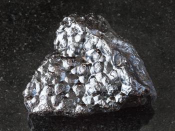 macro shooting of natural rock specimen - raw Hematite (Kidney Ore) stone on black granite background from Morocco