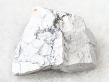 macro shooting of natural rock specimen - rough Howlite stone on white marble background