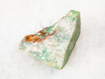 macro shooting of natural mineral - rough green Aventurine stone on white marble from Ural Mountains