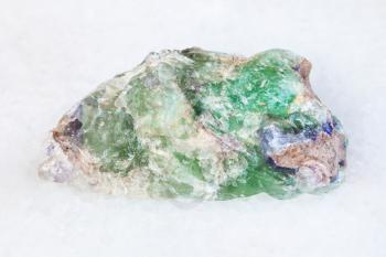 macro shooting of natural mineral - raw green Beryl, Chrysoberyl, Alexandrite gemstone on white marble from Ural Mountains