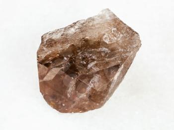 macro shooting of natural mineral - smoky quartz crystal on white marble from Ural Mountains