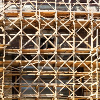 wooden scaffolding on multi-storey building in summer day