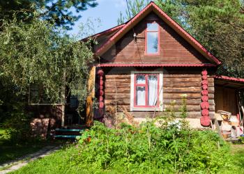 front view of rural log house on sunny summer day in Tver region of Russia