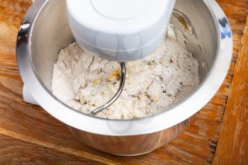 cooking of pie - kitchen processor kneads dough with egg