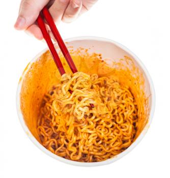 hand keeps red chopsticks with cooked spicy instant noodles isolated on white background