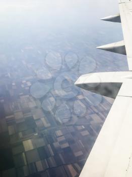 view of aircraft wing over country fields in Stavropol Krai of Russia from the airplane porthole in flight in september day