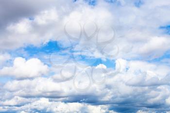 natural background - low dense cumulus clouds in blue sky on summer day