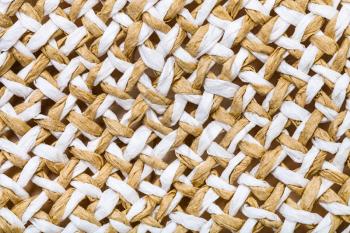 textile background - detail of summer straw hat from interwoven toyo fibers close up