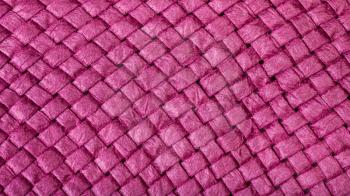 textile panoramic background - weaving of summer straw hat from purple toyo fibers close up