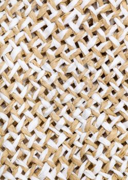 textile vertical background - weaving of summer straw hat from natural toyo fibers close up