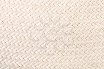 textile background - detail of straw hat from interwoven polished natural toyo fibers