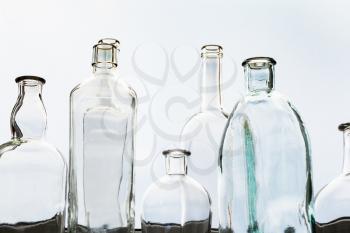 many empty bottles on home window sill and view of gray sky thought home window glass on background