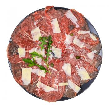 top view of served Carpaccio (thinly sliced raw beef fillet) decorated by Parmesan, Arugula and capers on black plate isolated on white background