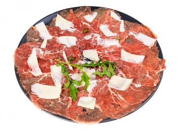 portion of Carpaccio (thinly sliced raw beef fillet) decorated by Parmesan, Arugula and capers on black plate isolated on white background