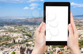 travel concept - tourist photographs of Uchisar village and roads in valley in Nevsehir Province in Cappadocia in spring in Turkey on smartphone with cutout screen with blank place for advertising