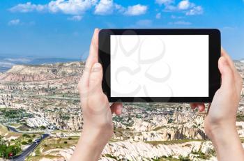 travel concept - tourist photographs of mountain valley in Nevsehir Province in Cappadocia in spring in Turkey on smartphone with empty cutout screen with blank place for advertising