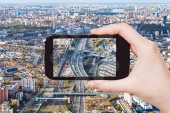 travel concept - tourist photographs of Third Ring Road and Railway Central Circle in Moscow city from observation deck on smartphone in Russia