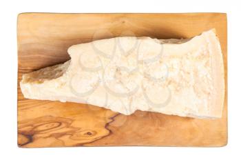 top view of piece of local italian Parmigiano Reggiano (Parmesan) hard cheese on olive wood cutting board isolated on white background