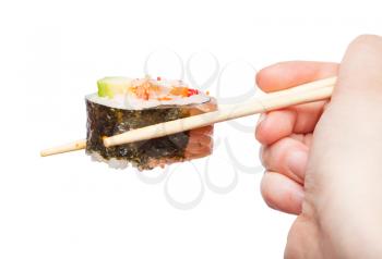 female hand with disposable chopsticks holds western-style sushi roll isolated on white background