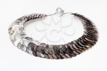 necklace from polished natural nacre discs on white paper background
