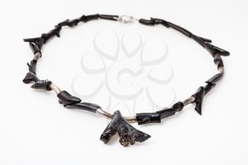 necklace from polished black coral twigs on white paper background