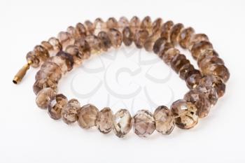 spiral necklace from faceted Smoky quartz gemsones on white paper background
