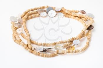 coiled African necklace from natural bone beads on white paper background