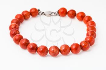 necklace from natural polished red coral balls on white paper background