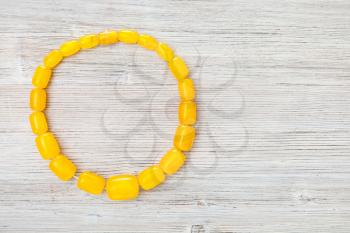top view of antique yellow amber necklace on gray wooden board with copyspace
