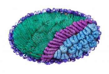 handcrafted oval brooch embroidered by various silk embroidery threads and violet beads isolated on white background