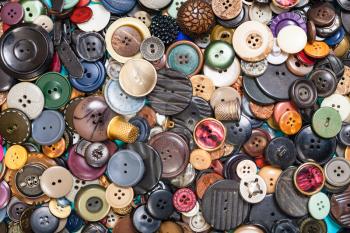 top view of heap of many different buttons close up on blue