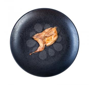 top view of half of fried quail on black plate isolated on white background