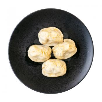 top view of portion of Manti (type of dumpling in turkic cuisine) on black plate isolated on white background