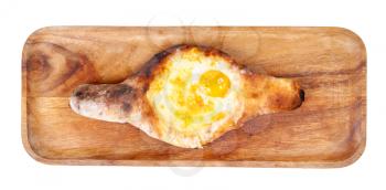 georgian cuisine - top view of Adjarian boat-shaped khachapuri with cheese, butter and egg yolk on wooden plate isolated on white background