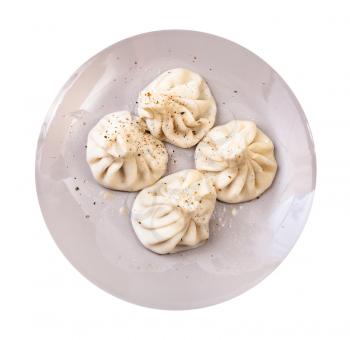 georgian cuisine - top view of cooked khinkali on gray plate isolated on white background