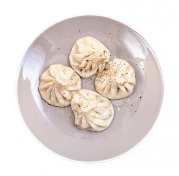 georgian cuisine - top view of four boiled khinkali on gray plate isolated on white background