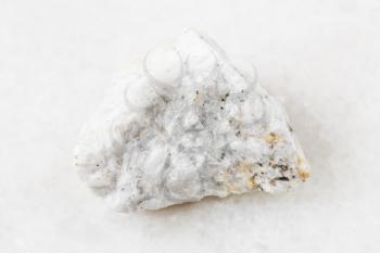 closeup of sample of natural mineral from geological collection - unpolished Baryte (Barite) ore on white marble background from Belorechensk deposit, Maykopsky District, Adygea, Russia