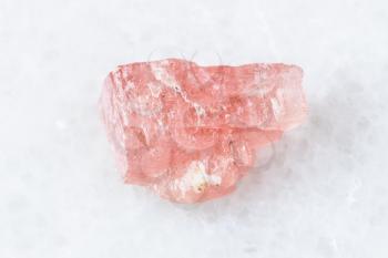 closeup of sample of natural mineral from geological collection - rough Rhodochrosite crystal on white marble background from Wutong mine, Liubao, Guangxi prov, China