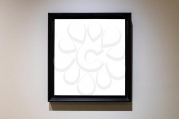 square black picture frame with cutout canvas on gray horizontal wall