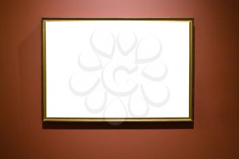 narrow bronze picture frame with cutout canvas on brown wall