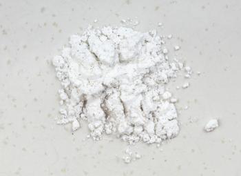 top view of pile of vanilla sugar (sugar powder with ground natural vanilla) close up on gray ceramic plate