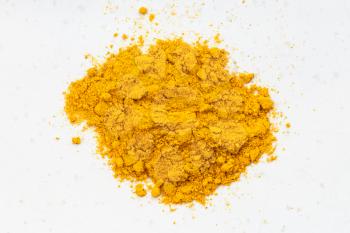 top view of pile of Turmeric (Curcuma) powder close up on gray ceramic plate