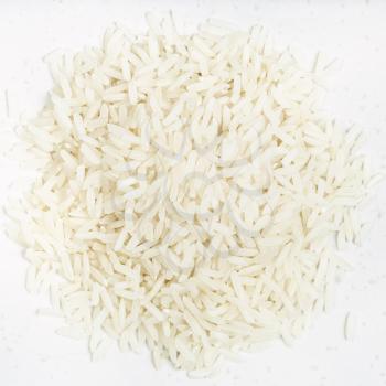 top view of pile of polished long-grain jasmine rice close up on gray ceramic plate