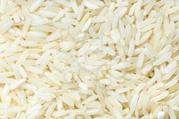 food background - uncooked polished long-grain jasmine rice