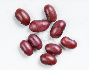several raw mexican red beans close up on gray ceramic plate