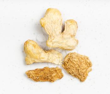 top view of several dried pieces of ginger on gray plate close up