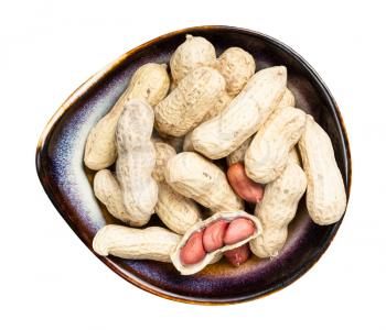 top view of peeled and whole peanuts in ceramic bowl isolated on white background