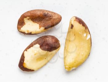 several raw brazil nuts close up on gray ceramic plate